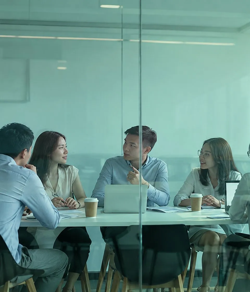 Đội ngũ doanh nghiệp họp bàn trong phòng kính