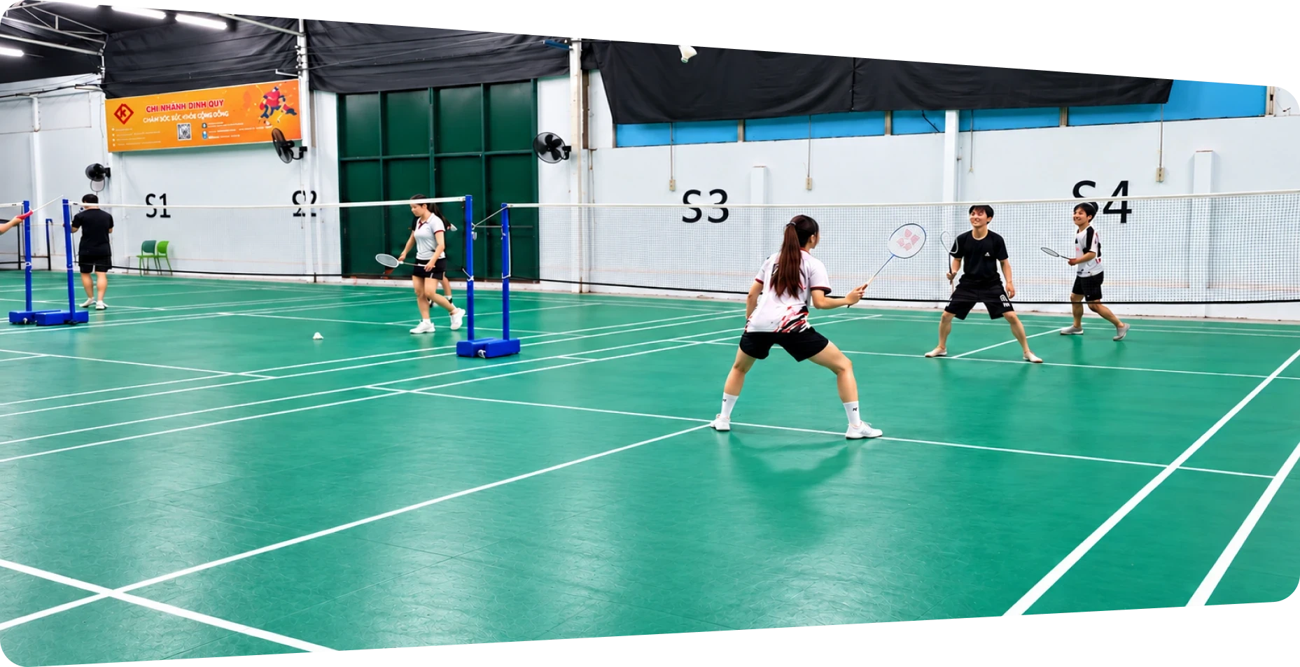 MIMA team members playing doubles on the badminton court