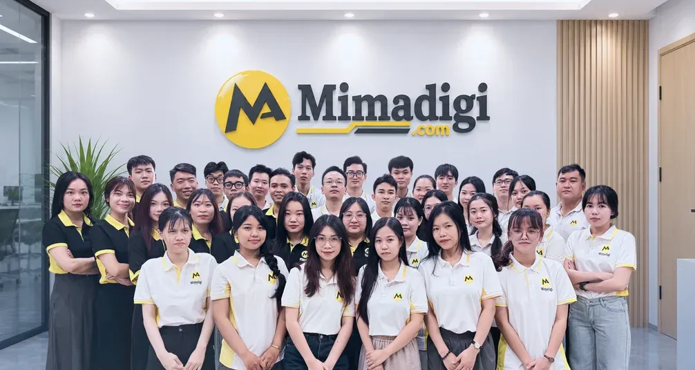 Toàn bộ nhân sự MIMA Digi đứng thành hàng trước bảng hiệu Mimadigi tại văn phòng