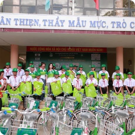 Students receiving gifts and bicycles in front of their school